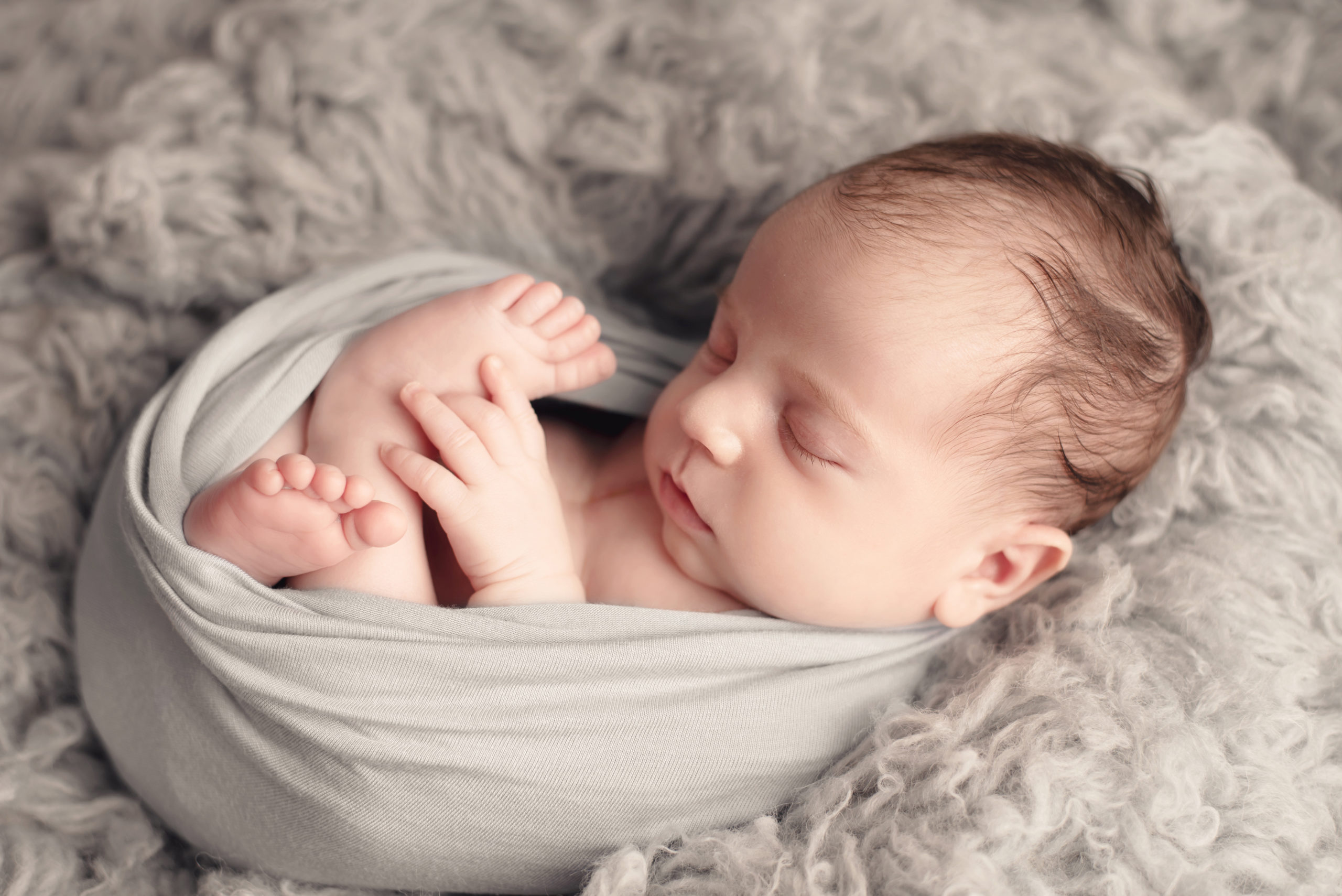 magnifique photo du bébé nouveau-né garçon Italien sur un flokati gis en laine prise hors de shooting photo nouveau-né en studio avec la famille
