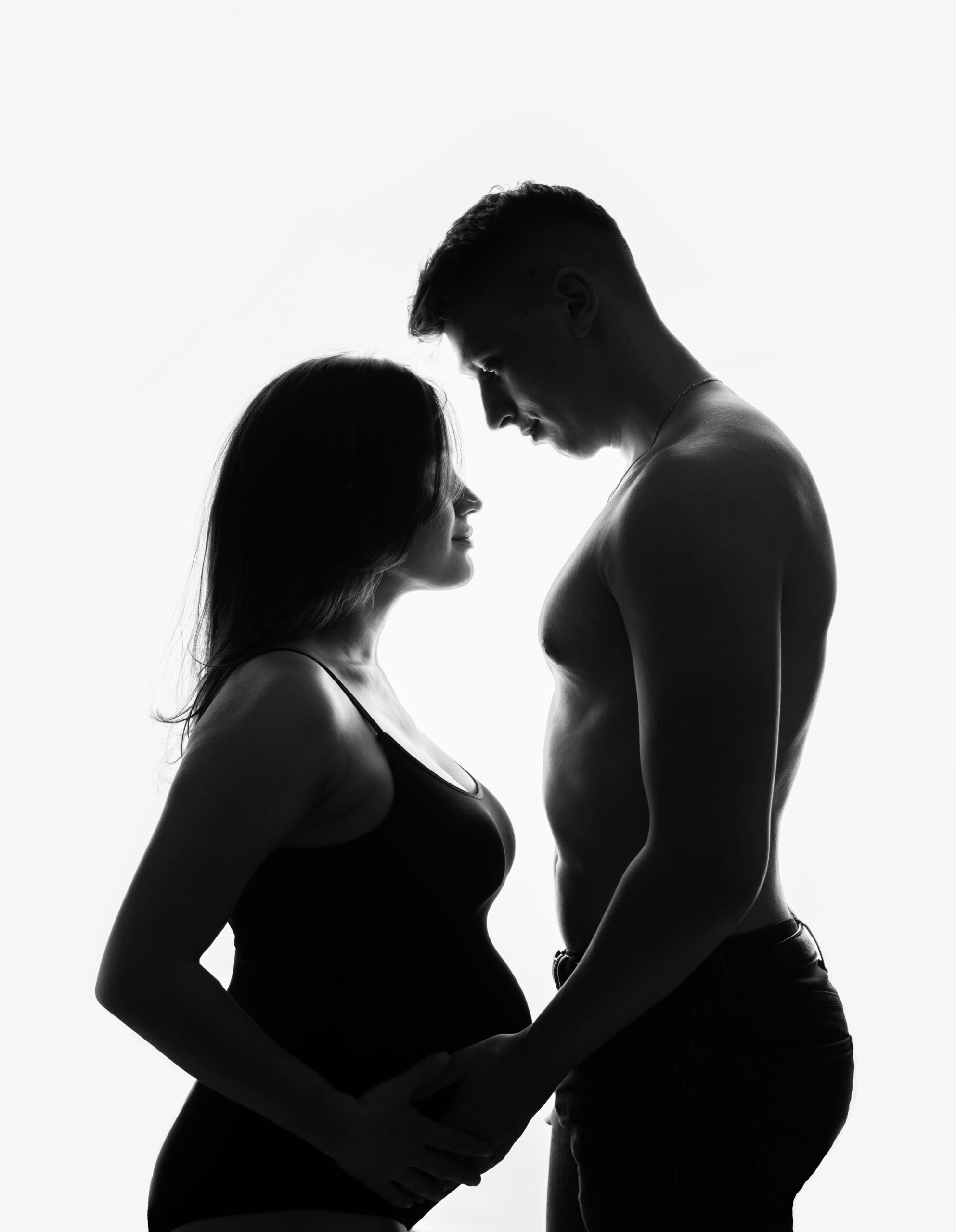 Photo grossesse de silhouette de belle femme enceinte avec future papa réalisée pendent une séance grossesse stylisée avec maquillage et coiffure professionnelles